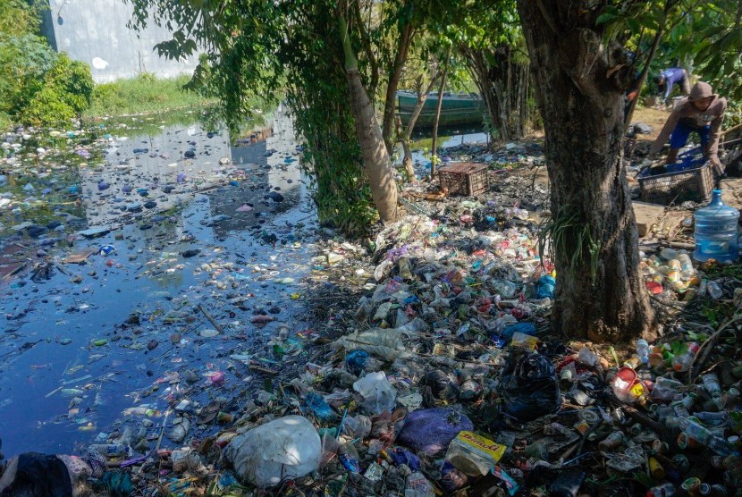 Petugas Dinas Lingkungan Hidup (DLH) membersihkan sampah di sekitaran Sungai Loji yang berwarna hitam akibat pencemaran limbah batik di Pekalongan, Jawa Tengah, Selasa (23/7/2019). 