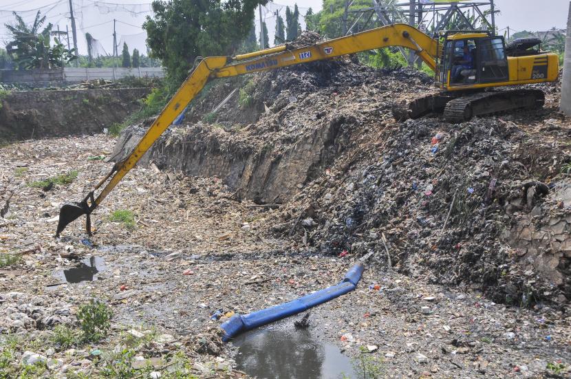 Petugas Dinas Lingkungan Hidup (DLH) menggunakan alat berat (eskavator) membersihkan sampah di Kali Jambe, Jatimulya, Kabupaten Bekasi, Jawa Barat