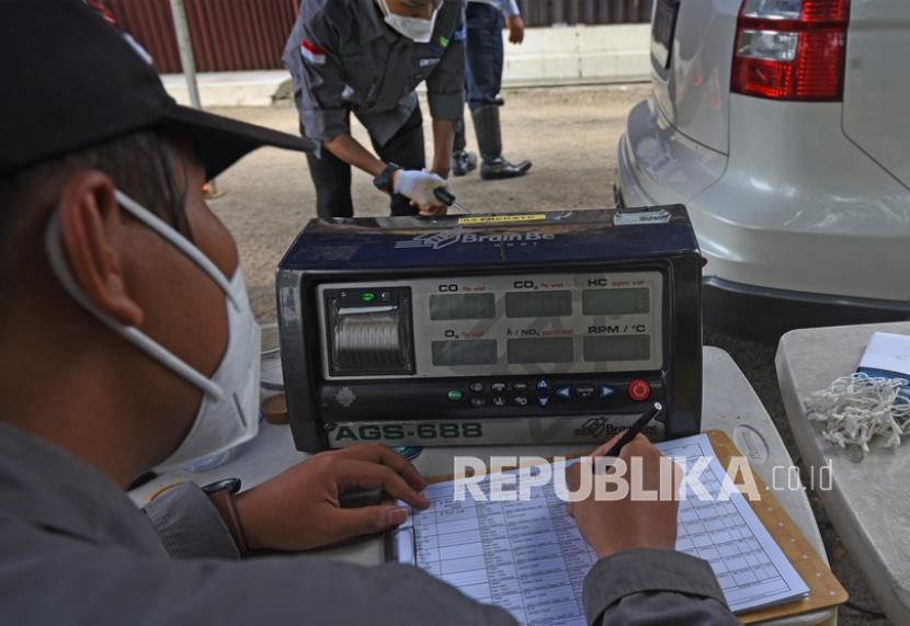 Petugas Dinas Lingkungan Hidup mencatat data emisi gas buang kendaraan roda empat saat uji emisi di Jalan Sudirman, Serang, Banten, Rabu (10/11/2021). 