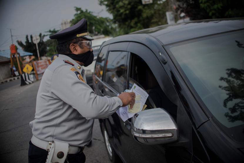 Petugas Dinas Pehubungan DKI Jakarta mengecek Surat Izin Keluar Masuk (SIKM) di Terminal Kalideres, Jakarta Barat.