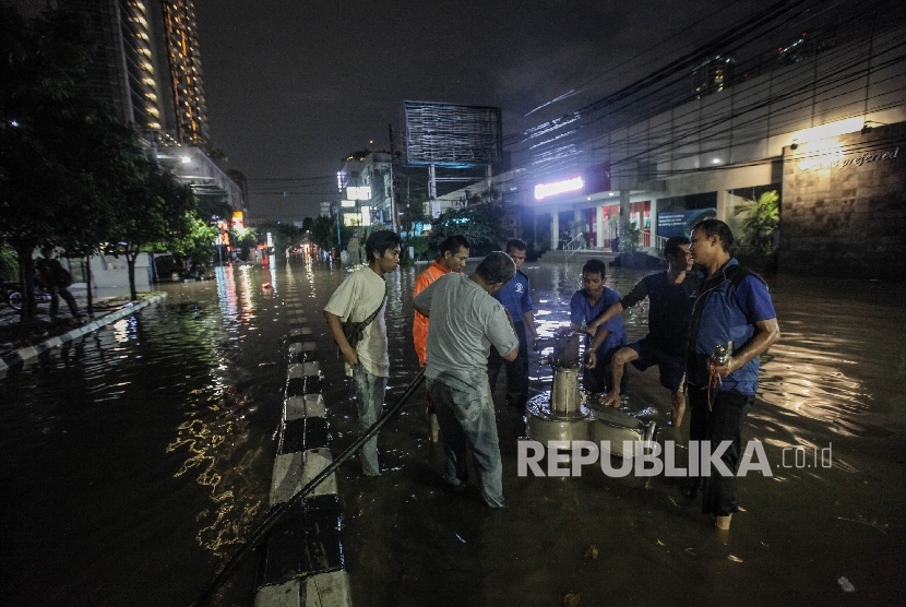Petugas Dinas Pekerjaan Umum memasang pompa air untuk menyedot banjir yang menggenangi Kawasan Bisnis Kemang, Jakarta Selatan, Ahad (25/9) malam. Walau tidak separah banjir besar sebelumnya, banjir masih menggenangi kawasan ini saat hujan deras mengguyur J