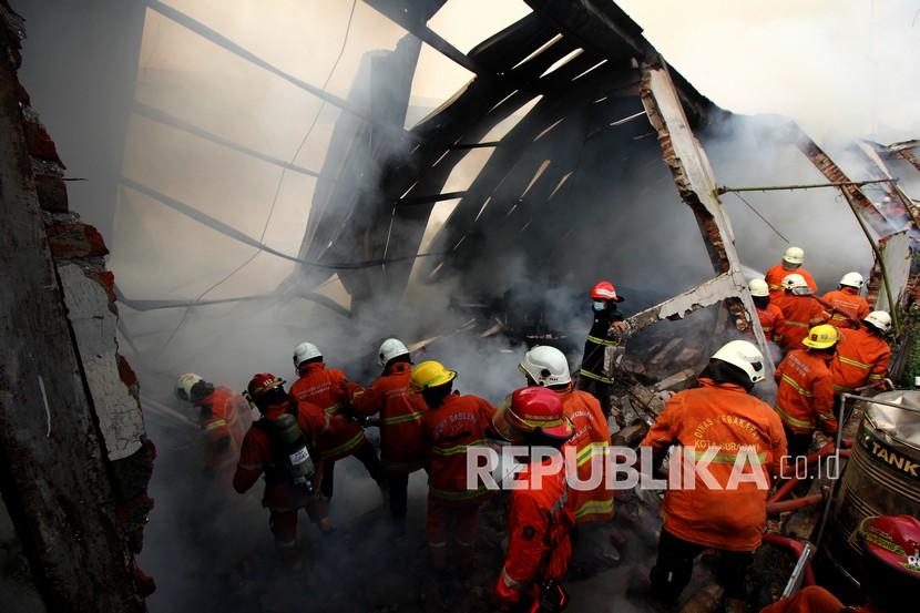 Petugas Dinas Pemadam Kebakaran Kota Surabaya melakukan pembasahan gudang yang terbakar di Jalan Simorejo Sari B, Surabaya, Jawa Timur, Selasa (27/10/2020). Sebanyak 22 unit kendaraan pemadam kebakaran dikerahkan untuk memadamkan gudang mebel yang ludes terbakar itu. 