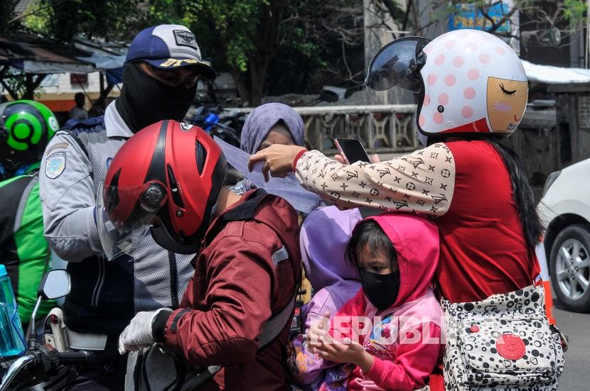 Petugas Dinas Perhubungan (Dishub) melakukan pengecekan identitas pengendara motor yang melintas di Kalimalang, Bekasi, Jawa Barat, Senin (27/4/2020). Pemeriksaan diperbatasan Bekasi dan Jakarta untuk menindaklanjuti kebijakan larangan mudik selama pandemi virus COVID-19. 