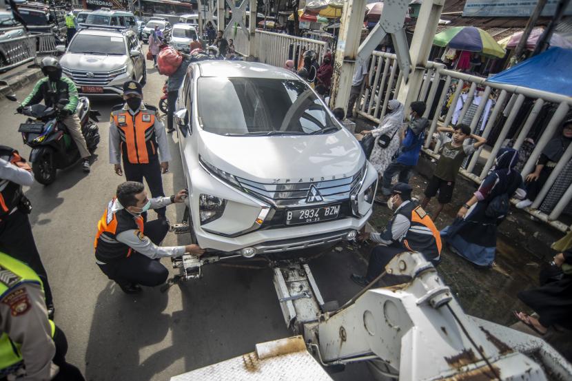 Petugas Dinas Perhubungan (Dishub) DKI Jakarta menderek sebuah mobil yang parkir sembarangan di kawasan Tanah Abang, Jakarta Pusat, Senin (28/3/2022). 