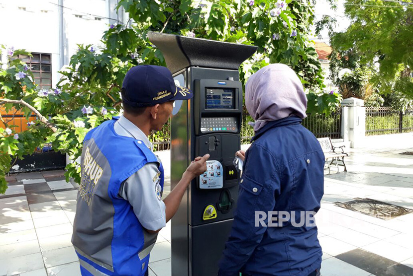 Petugas Dinas Perhubungan Kota Surabaya melakukan sosialisasi penggunaan alat parkir meter. Selain menyerukan pembayaran non tunai, Wali Kota Surabaya mengingatkan juru parkir untuk menghindari penggunaan peluit dalam masa pandemi.