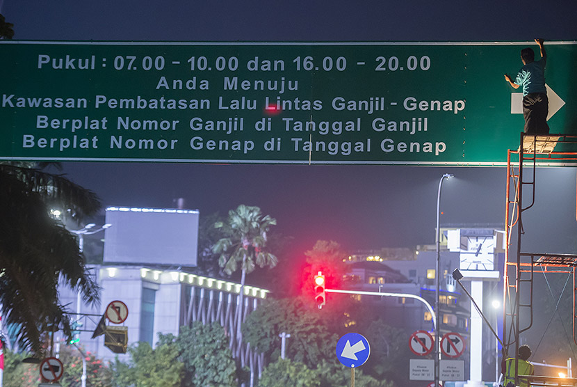 Petugas Dinas Perhubungan menyelesaikan pekerjaan pemasangan papan informasi penerapan sistem ganjil dan genap di Jalan Kebon Sirih, Jakarta, Sabtu (27/8).