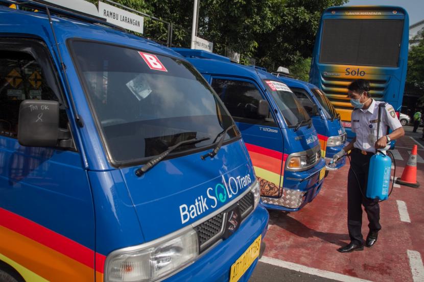 Petugas Dinas Perhubungan menyemprotkan cairan disifektan pada angkutan umum bus di kantor Dinas Perhubungan, Solo, Jawa Tengah, Selasa (17/3/2020).(Antara/Mohammad Ayudha)