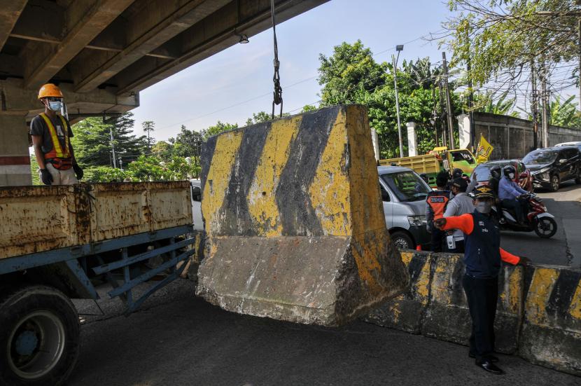 Petugas Suku Dinas Perhubungan Jakarta Timur memindahkan barrier beton di Jalan Laksamana Malahayati, Pondok Kelapa, Jakarta Timur, Kamis (28/7/2022). 