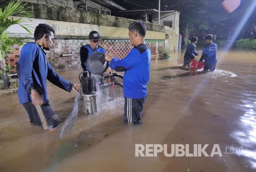 Petugas Dinas Tata Air menjaga agar pipa penghisap air tidak tersumbat sampah yang terhanyut banjir di Kawasan Kemang, Jakarta, Ahad (28/8). (Foto: Yogi Ardhi/Republika)