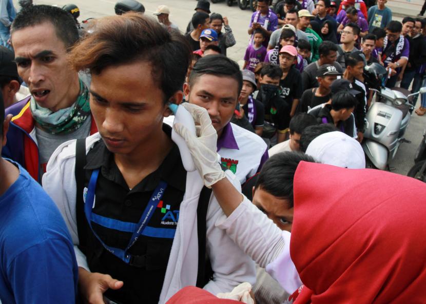 Petugas Dinkes Kabupaten Tangerang memeriksa suhu tubuh para penonton yang akan menyaksikan pertandingan Persita Tangerang melawan PSM Makassar di Stadion Sport Centre Tangerang, Banten, Jumat (6/3/2020). Pemeriksaan dilakukan untuk mengantisipasi penyebaran virus Corona. 