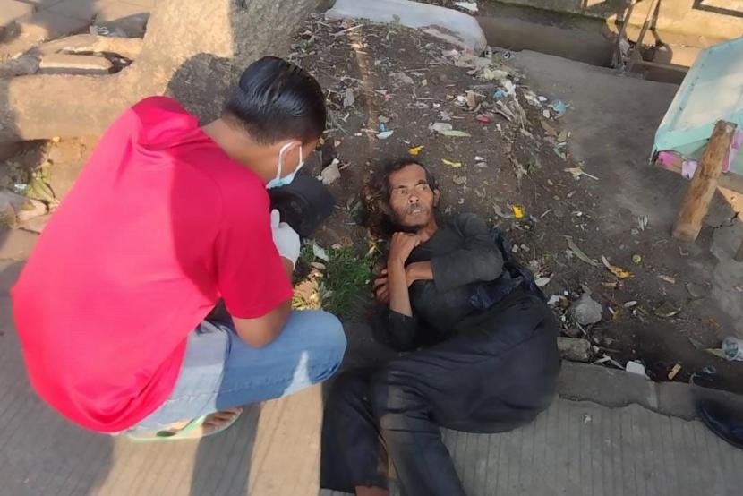 Petugas Dinsos Kota Bogor mengevakuasi ODGJ yang terbaring lemas di Simpang Tangkal Asem, Kelurahan Kebon Kelapa, Kecamatan Bogor Tengah, Kota Bogor, Jumat (19/8). 