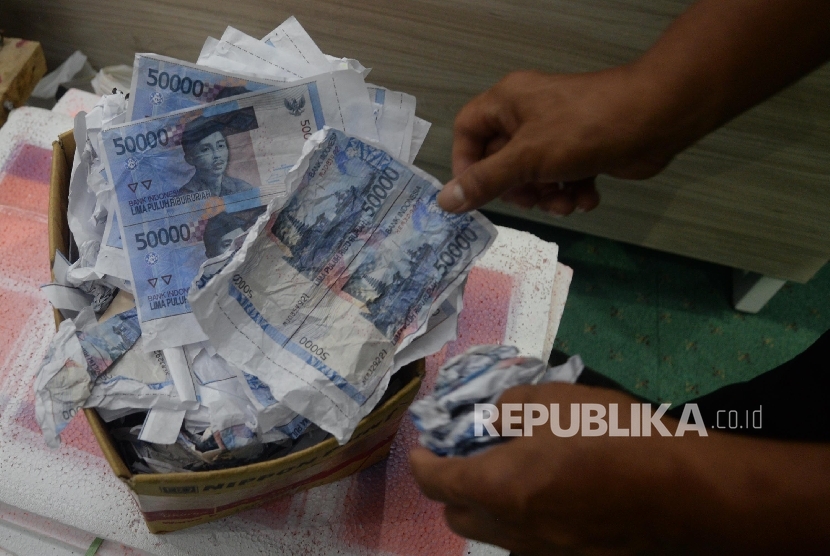Petugas Direktorat Tindak Pidana Ekonomi Khusus Bareskrim Polri memperlihatkan uang palsu saat rilis di Bareskrim Mabes Polri, Jakarta, Jumat (16/6). 
