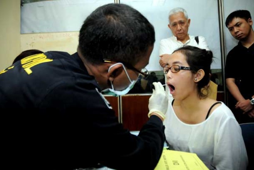 Petugas Disaster Victim Identification (DVI) Mabes Polri melakukan pengambilan sampel DNA dari salah satu keluarga korban jatuhnya pesawat Sukhoi di Bandara Halim Perdanakusuma, Jakarta, Jumat (11/5).