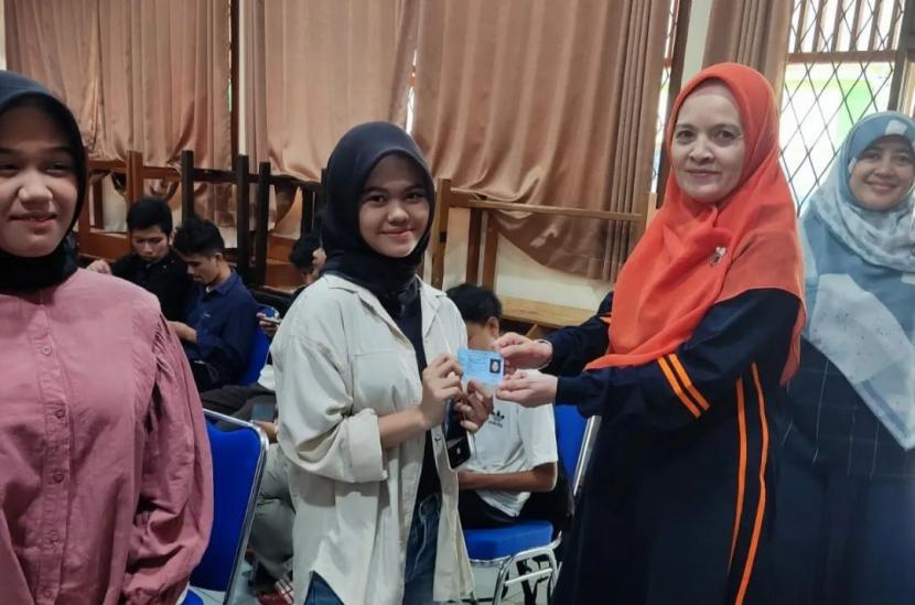 Petugas Disdukcapil Kota Sukabumi memberikan KTP-El ke pelajar MAN 1 Kota Sukabumi yang pertama kali melakukan perekaman KTP pada Mei 2023 lalu. 