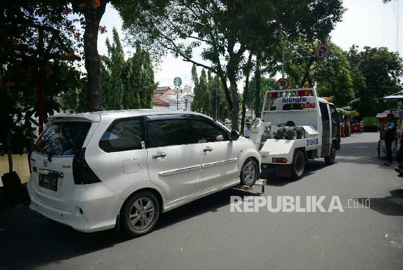  Petugas Dishub DKI Jakarta bersiap menderek mobil yang menyalahi aturan parkir di bahu jalan kawasan Pasar Baru, Jakarta, Selasa (25/10). (Republika/Prayogi)