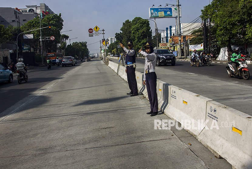 Petugas Dishub DKI Jakarta mengatur lalu lintas saat uji coba penutupan tiga simpang di kawasan Jalan Mampang Prapatan Raya, Jakarta, Sabtu (19/5).