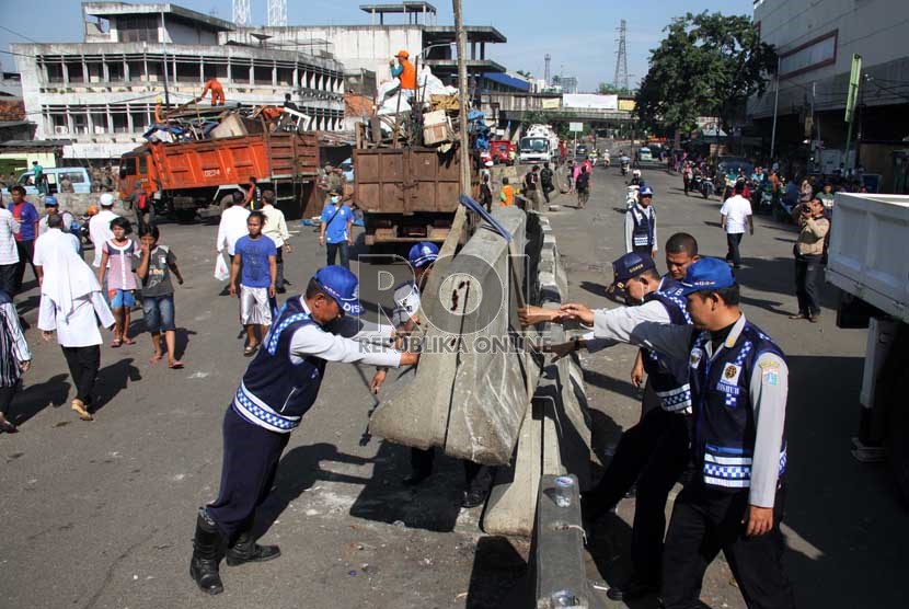 Petugas Dishub memasang pembatas jalan saat penertiban di kawasan Pasar Tanah Abang, Jakarta Pusat, Ahad (11/8). (Republika/ Yasin Habibi)