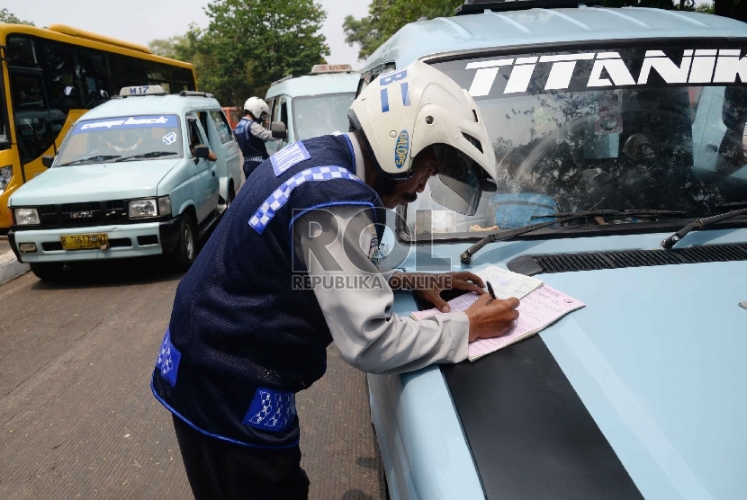 Petugas Dishub memeriksa surat kelengkapan angkutan umum di Terminal Pasar Minggu, Jakarta Selatan. (Republika/Yasin Habibi)