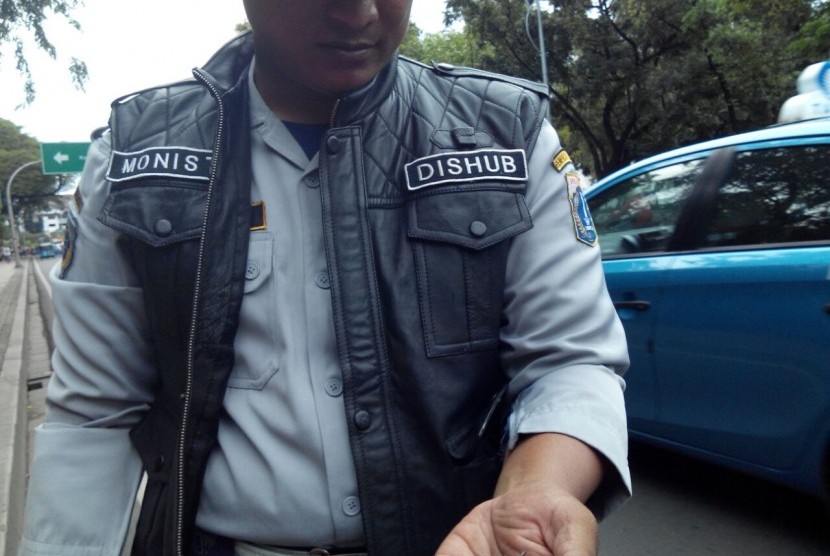 Petugas Dishub memungut ranjau paku di depan Istana Presiden, Jalan Merdeka Barat, Jakarta Pusat, Sabtu (14/1).