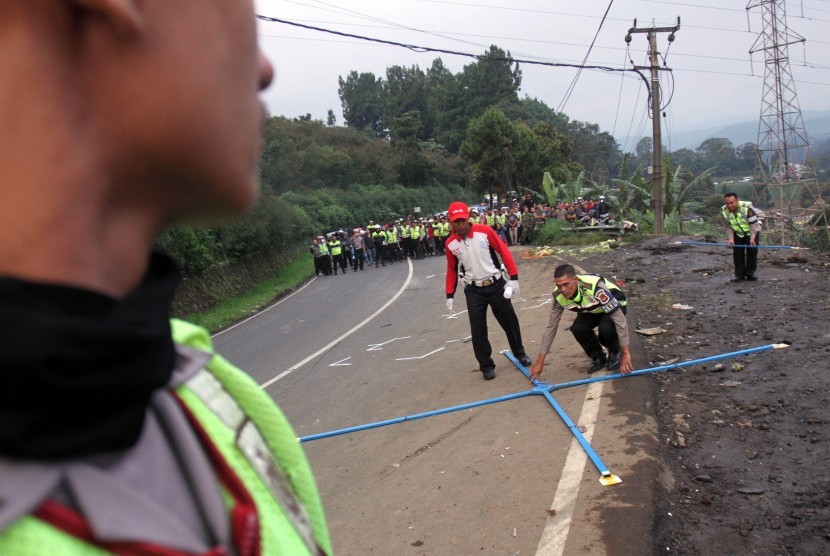Petugas Ditlantas Polda Jabar melakukan olah tempat kejadian perkara (TKP) kecelakaan beruntun di Jalan Puncak, Ciloto, Cipanas, Cianjur, Jawa Barat, Ahad (30/4). 