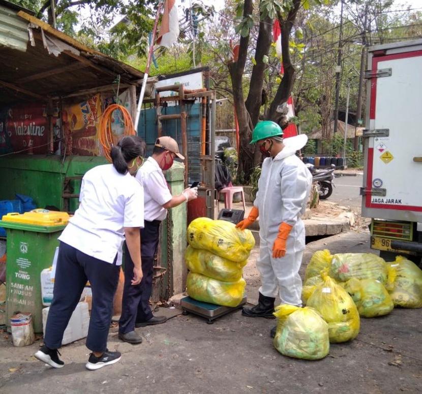 Petugas DLH DKI mengumpulkan masker bekas sekali pakai dari tumpukan sampah rumah tangga untuk dimusnahkan dengan cara diinsinerasi, Jumat (13/11). 