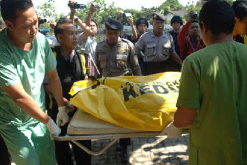 Petugas Dokkespol mengeluarkan kantong berisi jenazah terduga teroris yang tiba di RS Bhayangkara Polda Jatim, Surabaya, Senin (22/7). Detasemen Khusus (Densus) 88 Antiteror Polri menembak mati dua terduga teroris bernama Dayat dan Riza yang merupakan angg
