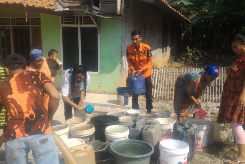 Petugas DPKPB dan PDAM Kabupaten Purwakarta, mendistribusikan bantuan air bersih bagi warga yang terdampak kekeringan, Kamis (25/7). 
