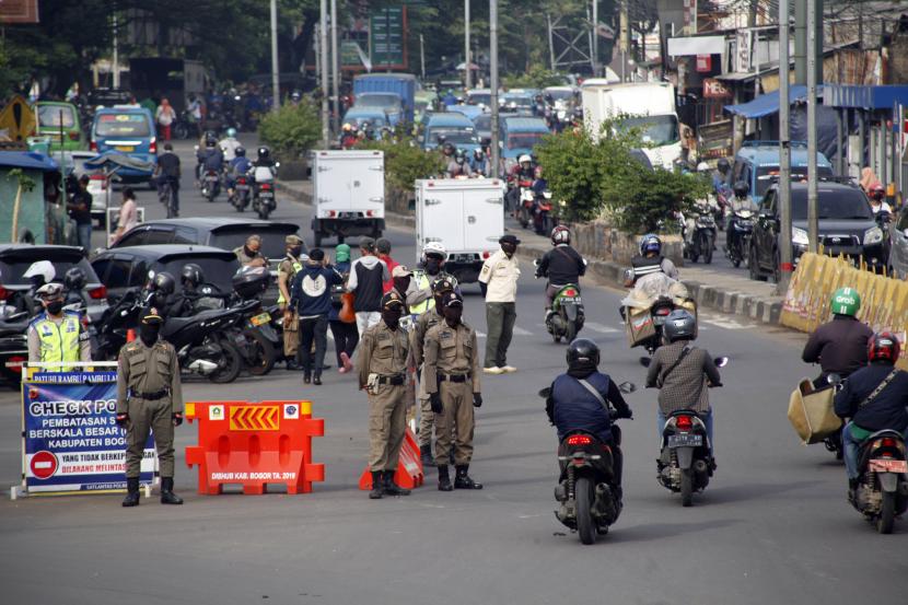 Petugas gabungan berjaga di check point pembatasan sosial berskala besar (PSBB) di Jalan Raya Bogor, Cibinong, Bogor, Jawa Barat.