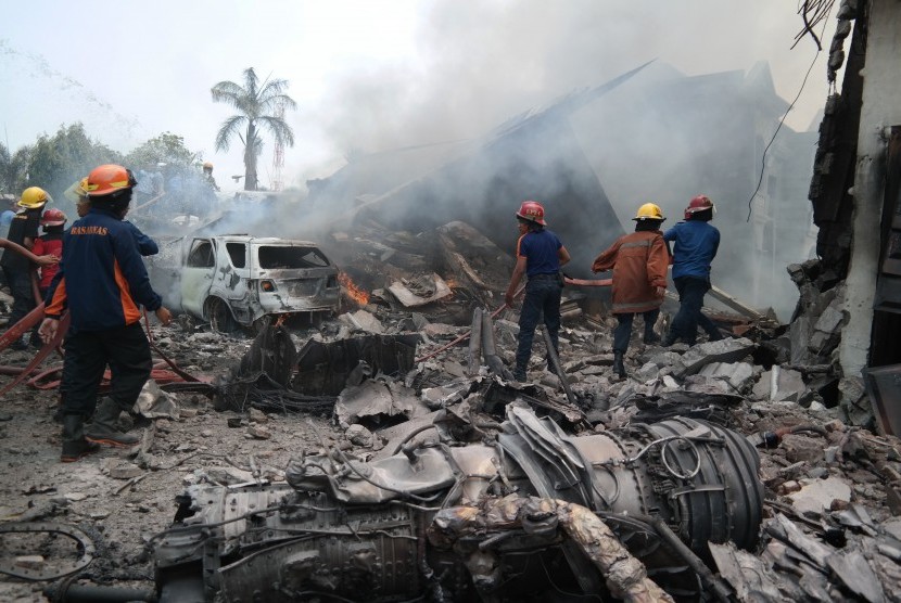 Petugas gabungan berusaha memadamkan api pesawat Hercules yang jatuh, di Jalan Jamin Ginting, Medan, Sumatera Utara, Selasa (30/6).