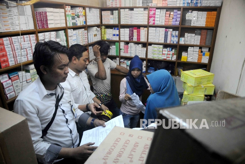 Petugas gabungan dari BPOM DKI, Ditreskrimsus Polda Metro Jaya dan Dinas Kesehatan DKI melakukan razia obat ilegal di salah satu kios Pasar Pramuka, Jakarta, Rabu (7/9).  (Republika/Agung Supriyanto)