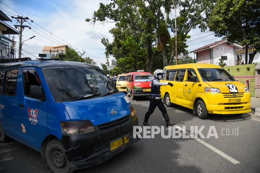 Petugas gabungan dari Satlantas Polrestabes Medan, Dishub Medan dan Badan Narkotika Nasional Provinsi (BNNP) Sumatera Utara memberhentikan sejumlah Angkutan Kota saat razia di Jalan Gajah Mada, Medan,? Selasa (14/12/2021). Razia gabungan tersebut sebagai upaya menertibkan angkot dan sopir nakal yang membahayakan penumpang.