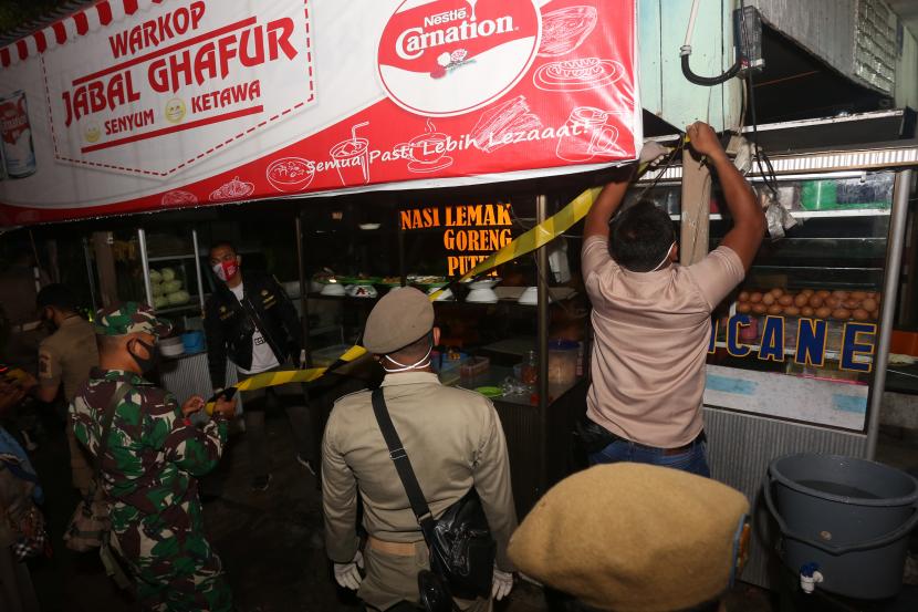 Petugas gabungan dari Satpol PP, TNI/Polri, Diskominsa dan Dinas Kesehatan menyegel salah satu warung kopi di Meulaboh, Aceh Barat, Aceh, Selasa (1/6/2021). Penyegelan warung tersebut dilakukan karena melanggar aturan protokol kesehatan COVID-19.