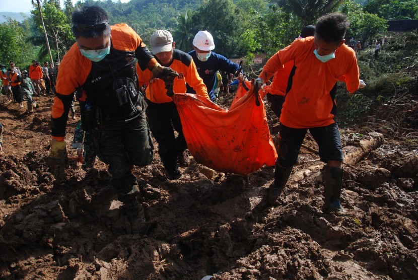 Petugas gabungan dari TNI, BASARNAS, Polri, relawan dan warga membawa kantong jenazah berisi korban tanah longsor di Caok, Loano, Purworejo, Jawa Tengah, Selasa (21/6). 