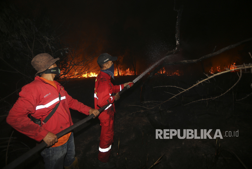 Petugas gabungan Manggala Agni Daops Banyuasin, BPBD Prov Sumsel, BPBD OI, TNI dan Polri melakukan pemadaman kebakaran lahan di Desa Pelabuhan Dalam, Pemulutan, Ogan Ilir (OI), Sumatera Selatan, Jumat (8/4). 