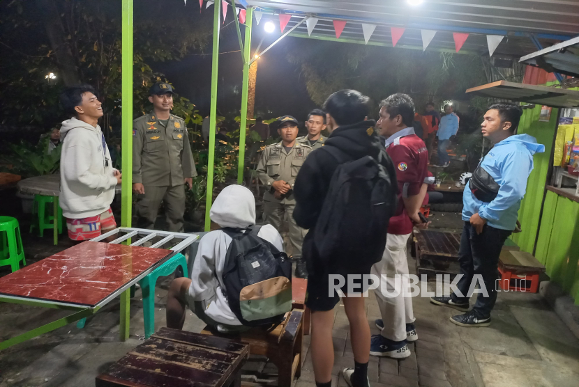 Petugas Gabungan Melakukan Patroli Pembatasan Jam Malam Bagi Siswa di Kota Cimahi, Jawa Barat.