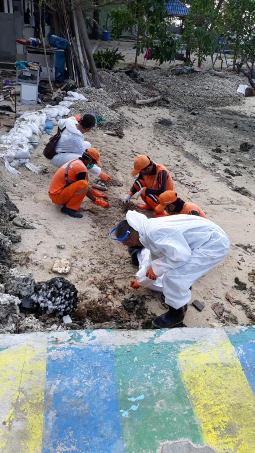 Petugas gabungan membersihkan tumpahan minyak di Pulau Pari, Kepulauan Seribu.