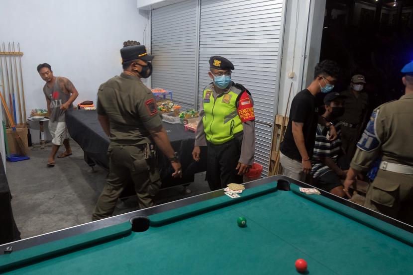 Petugas gabungan membubarkan warga yang bermain biliar saat sidak Pemberlakuan Pembatasan Kegiatan Masyarakat (PPKM).