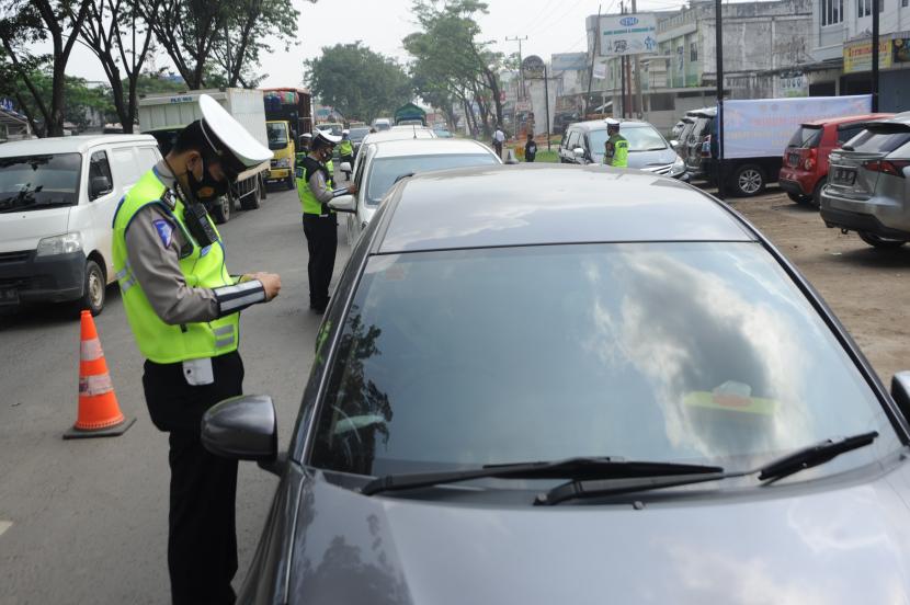 Petugas gabungan memeriksa dokumen pengendara di posko penyekatan KM 12 Palembang, Sumsel. Pemprov Sumsel memperbaiki jalan agar aman dan nyaman dilalui mudik lebaran.