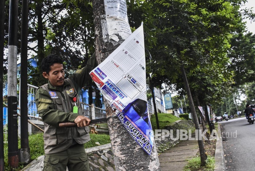 Petugas gabungan mencopot Alat Peraga Kampanye (APK) Pemilu 2019, Ahad (14/4). 