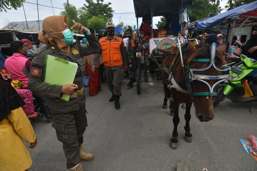 Petugas gabungan menegur pedagang dan warga yang tidak menggunakan masker saat operasi yustisi COVID-19 di Pasar Tradisional Tawaeli di Palu, Sulawesi Tengah, Selasa (11/5/2021). Operasi yang dilaksanakan oleh petugas gabungan dari Pemerintah Kota Palu, TNI dan Polri pada pusat keramaian tersebut bertujuan untuk menekan penyebaran COVID-19 di masyarakat terutama menjelang perayaan Idul Fitri.