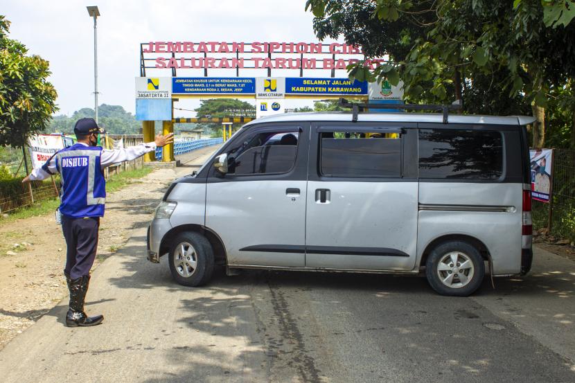 Petugas gabungan mengarahkan pemudik roda empat untuk berputar arah di perbatasan Bekasi-Karawang, Rabu (6/5).