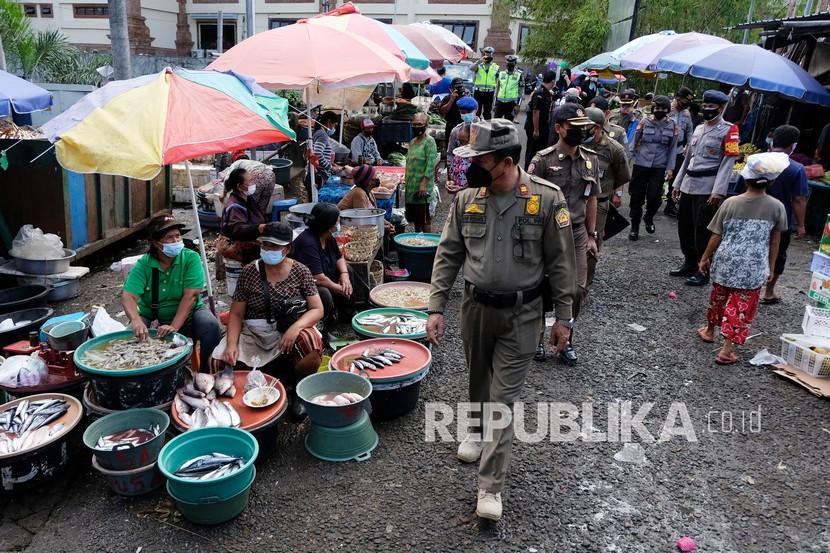 Petugas gabungan mengawasi pedagang dan pengunjung pasar supaya tertib menggunakan masker  di Pasar Kumbasari, Denpasar, Bali, (Ilustrasi)