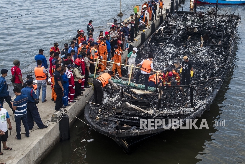 Petugas gabungan mengevakuasi korban yang terbakar di dalam kapal motor Zahro Express di dermaga Muara Angke, Jakarta, Ahad (1/1).ANTARA FOTO/M Agung Rajasa