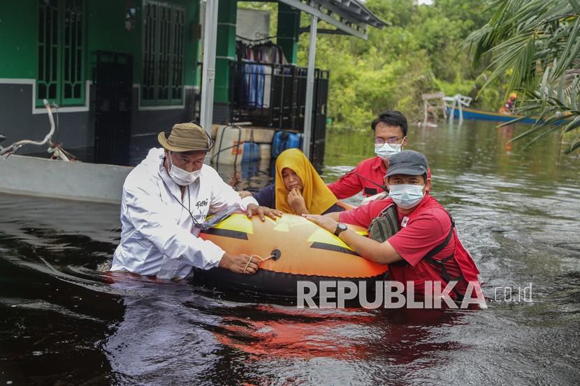 Petugas mengevakuasi warga terdampak banjir (ilustrasi).