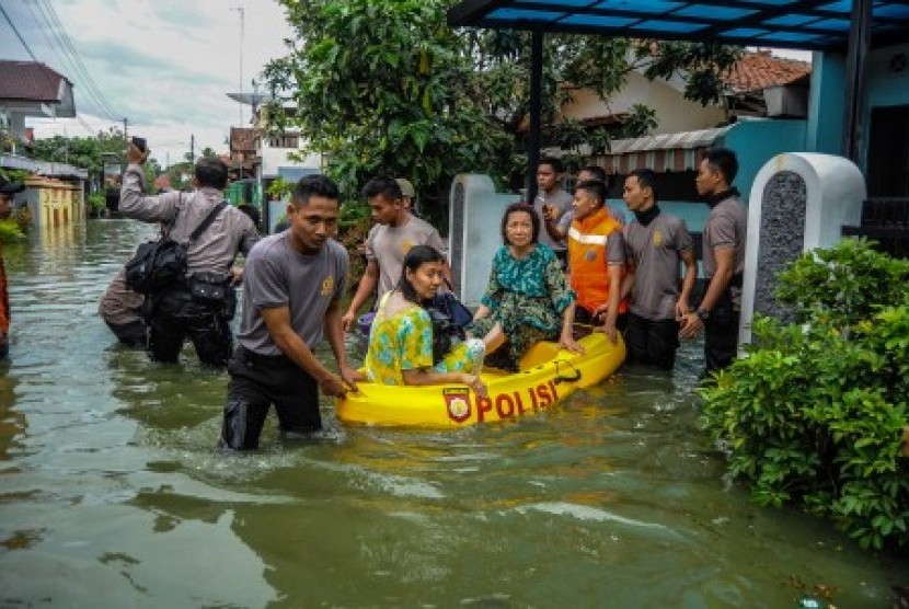 Petugas gabungan mengevakuasi warga terdampak banjir di Kecamatan Pekalongan Utara, Jawa Tengah, Jumat (1/12). Menurut data kecamatan setempat, sebanyak 1.300 warga dari tujuh kelurahan dievakuasi untuk menghindari banjir akibat dari curah hujan tinggi dan gelombang laut yang besar sebagai dampak siklon tropis dahlia. 