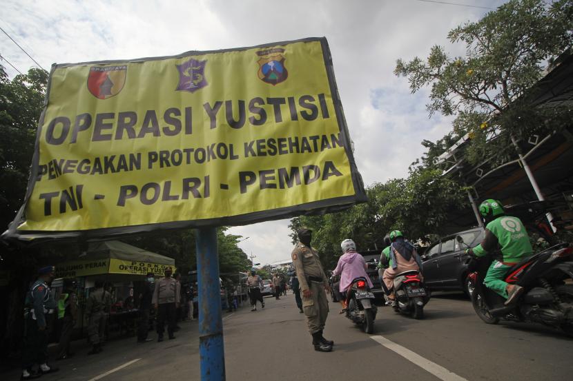 Petugas gabungan menggelar operasi yustisi penegakan protokol kesehatan di depan Posko PPKM Mikro Kelurahan Ampel, Surabaya, Jawa Timur. 