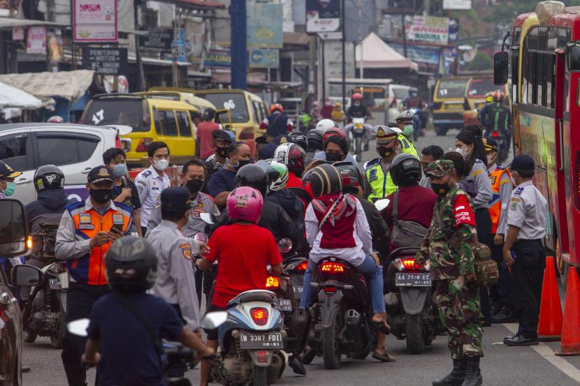 Petugas gabungan menghalau pemudik sepeda motor saat hari pertama penyekatan larangan mudik di Karawang, Jawa Barat, Kamis (6/5/2020). Penyekatan akses transportasi tersebut sebagai tindak lanjut kebijakan larangan mudik Lebaran pada 6 -17 Mei 2021 yang berlaku bagi kendaraan pribadi, angkutan umum dan motor kecuali mobil pemadam kebakaran, angkutan logistik dan kebutuhan pokok serta ambulans.