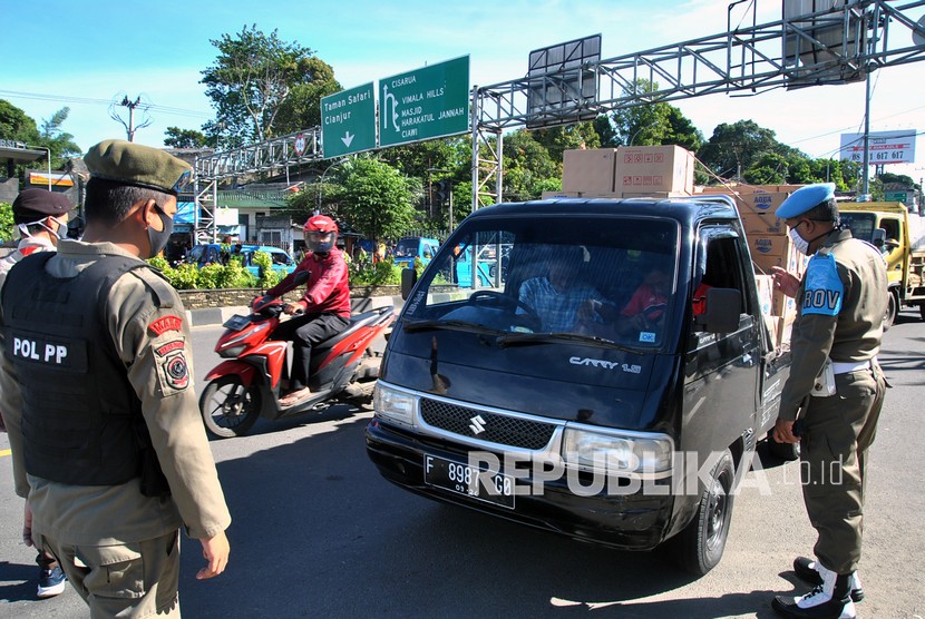 Petugas menghentikan kendaraan di Simpang Gadog, Kabupaten Bogor, Jawa Barat, untuk memeriksa surat hasil rapid test antigen (ilustrasi). Dari hasil rapid test antigen secara acak terhadap 167 orang, enam orang didapti reaktif dan dilarang pergi ke Kawasan Puncak.