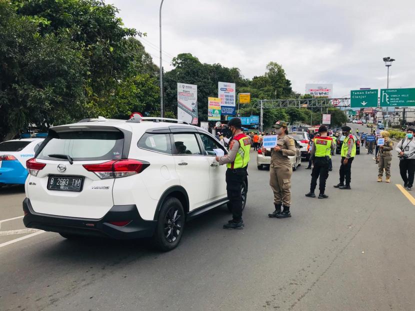 Petugas gabungan Satgas Covid-19 Kabupaten Bogor meminta surat hasil rapid test antigen kepada wisatawan yang hendak berangkat menuju Jalan Raya Puncak, Kamis (31/12).