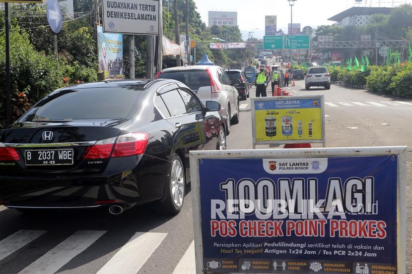 Petugas gabungan mengarahkan pengendara saat pemberlakuan ganjil-genap di jalur wisata Puncak, Gadog, Kabupaten Bogor. Penerapan ganjil-genap akan berlakudari Selasa-Ahad (21-26/3/20230.
